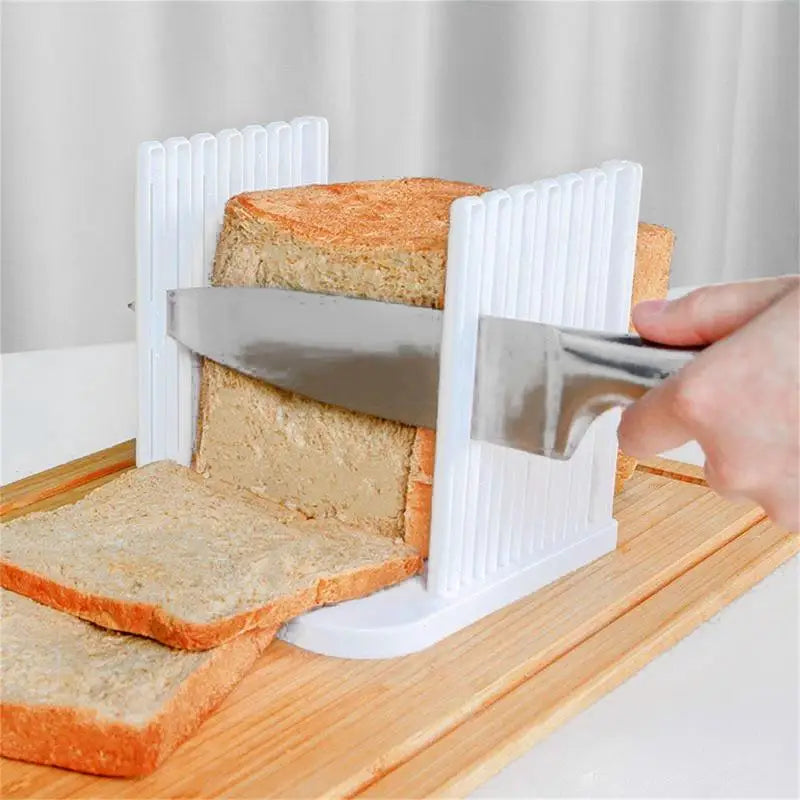 Plastic bread slicer guide with knife cutting even slices on wooden board.
