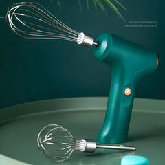 Electric handheld whisk with two stainless steel beaters on a green surface.