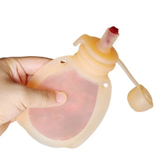 Hand holding a soft silicone reusable water pouch with a red cap on the spout.